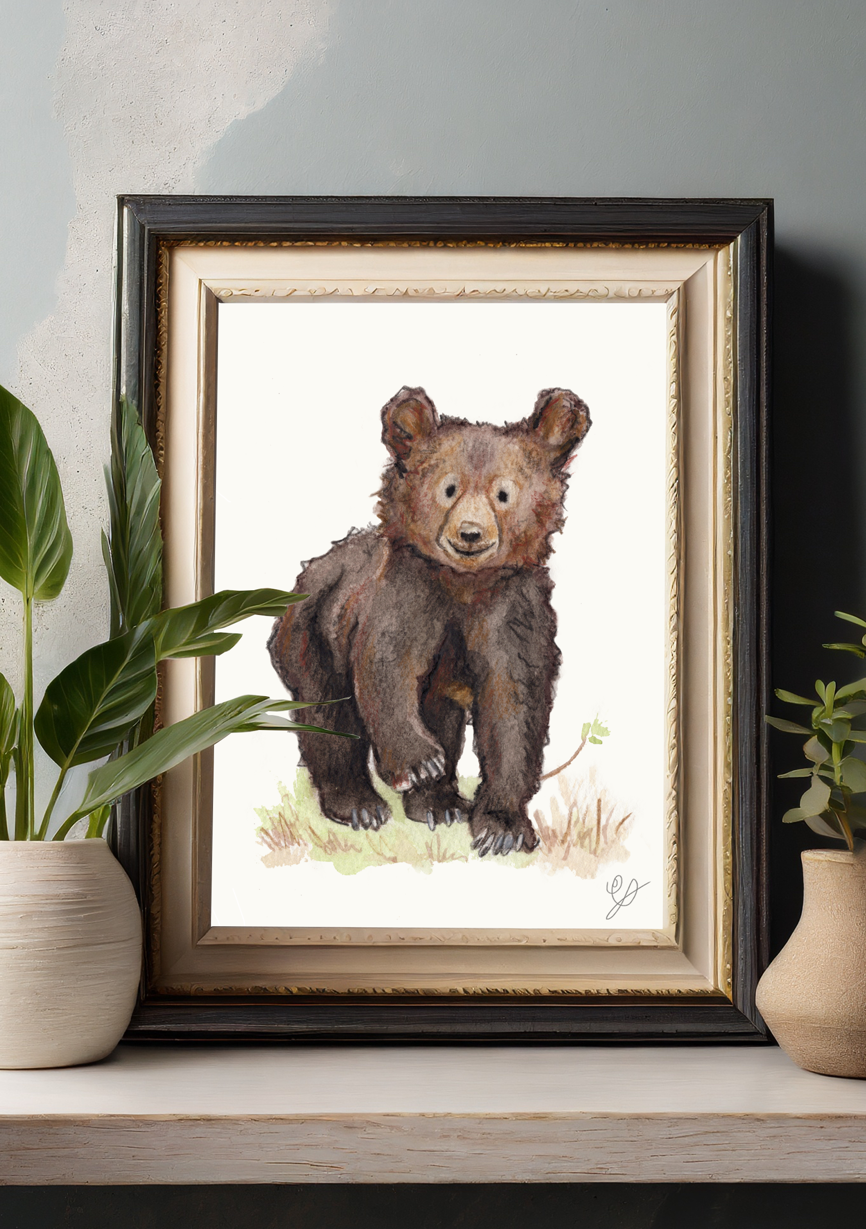 A framed print of a watercolour painting of a bear cub